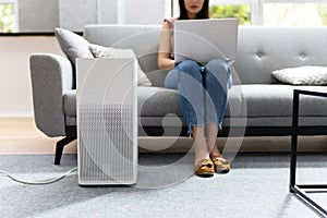 Woman In Living Room Using Air Cleaner