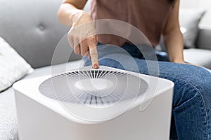 Woman In Living Room Using Air Cleaner
