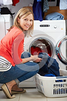 Woman Loading Clothes Into Washing Machine