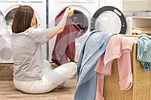 Woman Loading Dirty Clothes In Washing Machine For Washing In modern Utility Room