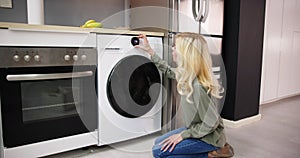 Woman Loading Dirty Clothes In Washing Machine For Washing