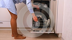 Woman loading dishes in the dishwasher, high angle view of dishes in the dishwasher in the kitchen.