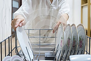 Woman loading dishwasher. view from the inside of the dishwashing machine