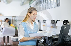 Woman loading ream of paper into printer