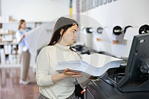 Woman loading ream of paper into printer