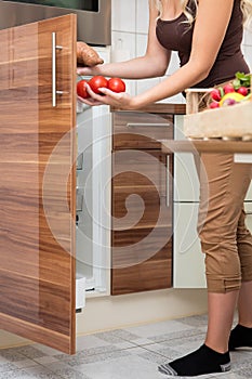 Woman loading tomatoes in the larder