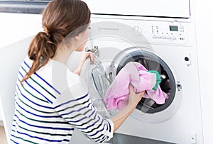 Woman loading washing machine