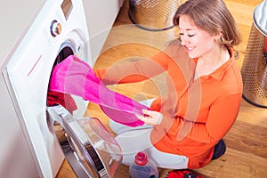 Woman loading washing machineWoman Loading Dirty Clothes In Washing Machine For Washing