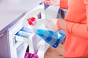 Woman loading washing machineWoman Loading Dirty Clothes In Washing Machine For Washing