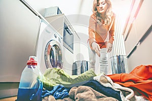 Woman loading washing machineWoman Loading Dirty Clothes In Washing Machine For Washing