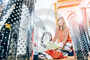 Woman loading washing machineWoman Loading Dirty Clothes In Washing Machine For Washing