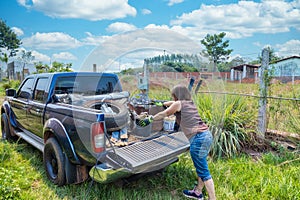 A woman loads garbage onto a pickup truck in Paraguay.