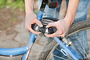 Woman locking bicycle with combination lock