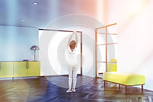 Woman in loft living room with yellow cabinet