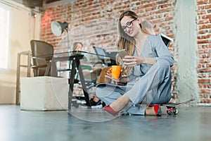 Woman in lofty office sitting on the floor