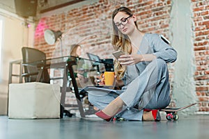 Woman in lofty office sitting on the floor