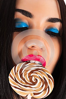 Woman with lollipop. Beautiful bright makeup