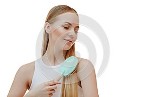 woman with long beautiful blond hair isolated on white background holds hairdressing accessories. Dyeing and hair care. Shiny
