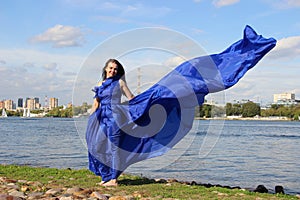 Woman in a long blue dress that fluttered in the wind. River