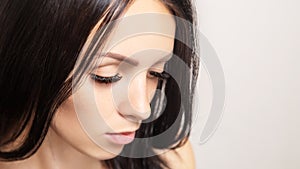 Woman with long brown eyelashes. Female beauty portrait on a light background. Eyelash extensions, care, beauty and spa concept