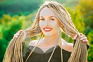 Woman with long dreadlocks. Smilling girl outdoor portarit. Rastafarian girl. photo