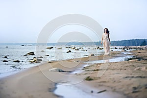 Woman in a long dress on the shore