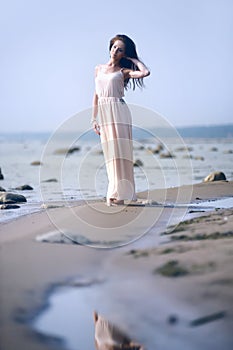 Woman in a long dress on the shore