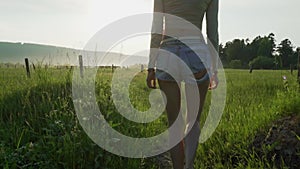 A woman with long hair in a field of greenery. Modeling and posing