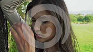 A woman with long hair in a field of greenery. Modeling and posing