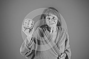 Woman with long hair hold alarm clock.