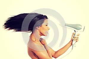 Woman with long hair holding blow dryer