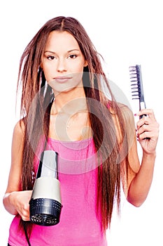 Woman with long hair holding blow dryer and comb
