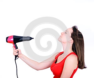 Woman with long hair holding strong blow dryer isolated on white