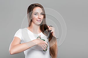 Woman with long hair holds scissors