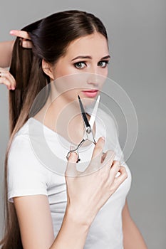 Woman with long hair holds scissors