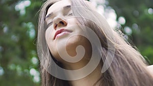 Woman with long hair raises hair up senses oneness with nature female feel unity