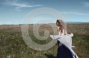 Woman with long tousled hair next to the wind turbine