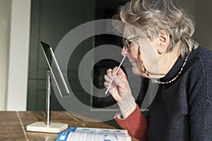 A woman looing in a mirror taking a covid-19 home testing nasal swab photo