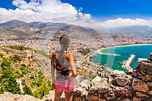 Woman look on landscape of Alanya with marina and Kizil Kule red tower in Antalya district, Turkey, Asia. Famous tourist