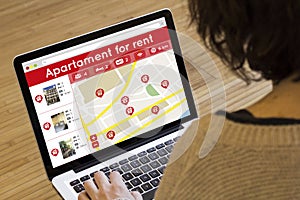 Woman lookin apartment for rent on her laptop