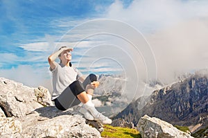 Woman looking ahead on top of the mountain