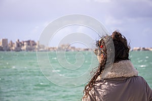 Woman looking at Alexandria city, Egypt, sky with clouds