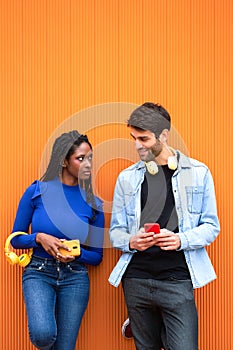 Woman looking annoyed and angry at her boyfriend while he's using his mobile phone.