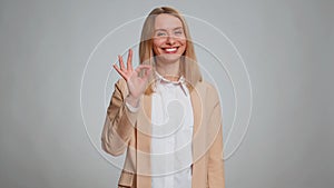 Woman looking approvingly, showing ok approve feedback gesture like sign positive something good
