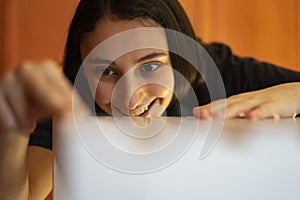 Woman looking and assembling a white piece of furniture.