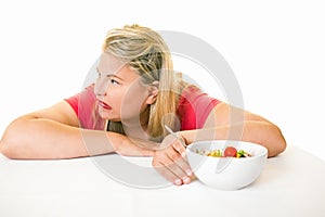 Woman looking away from bowl of healthy salad