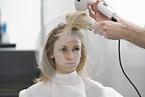 Woman Looking Away While Hairstylist Setting Her At Parlor