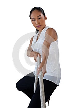 Woman looking away while pulling rope