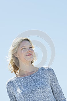 Woman Looking Away While Smiling Against Clear Sky