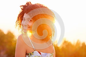Woman looking back over her shoulder with sun flare